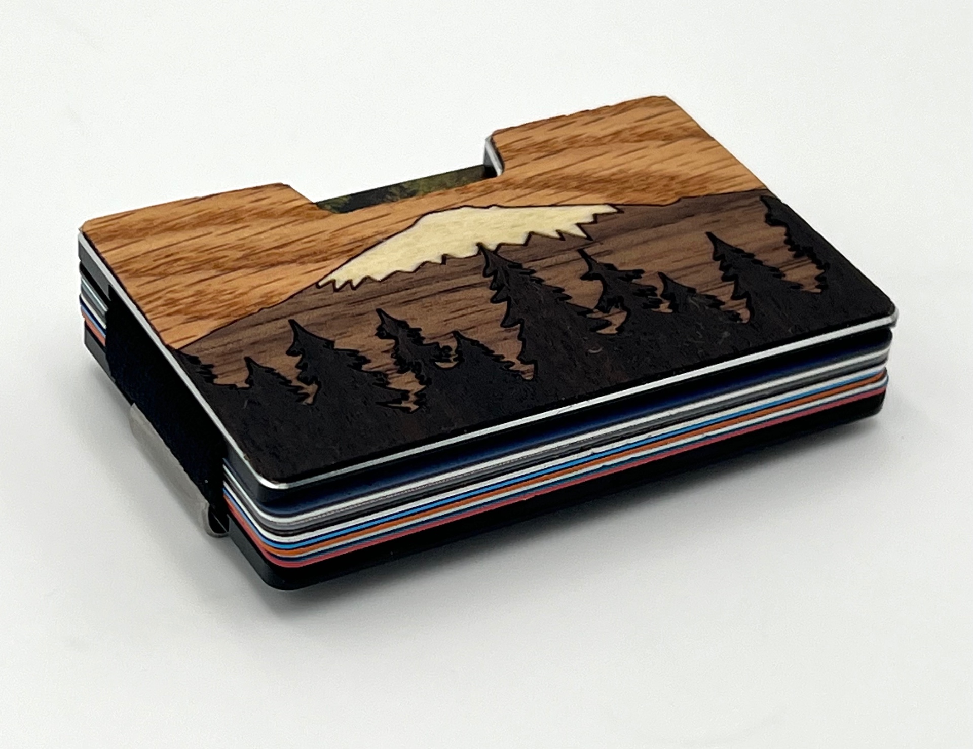 Angled view of the mountain and pines wood inlay wallet loaded with cards