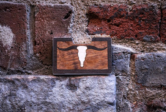 Longhorn skull wood inlay wallet displayed against brick