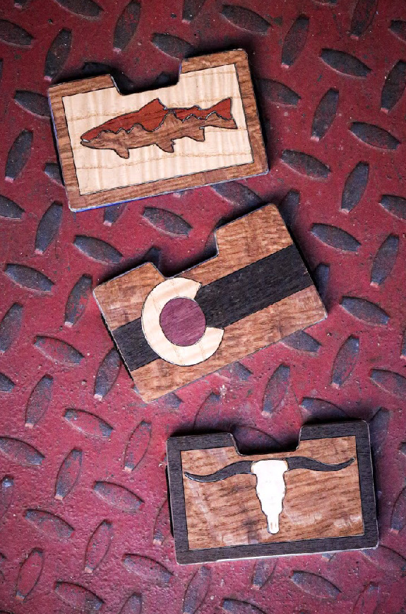 Trout, Colorado and longhorn wallets arranged on metal