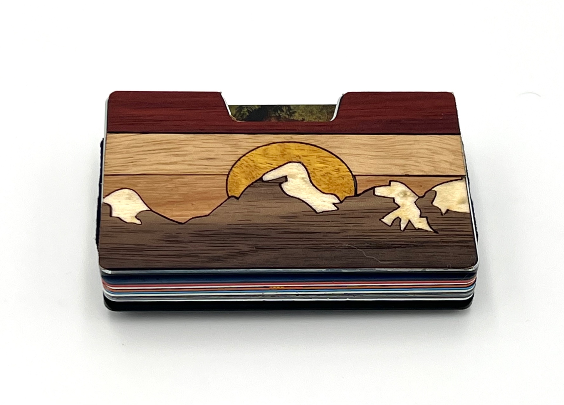 Wood inlay wallet with a yellow sun rising behind snow-capped peaks